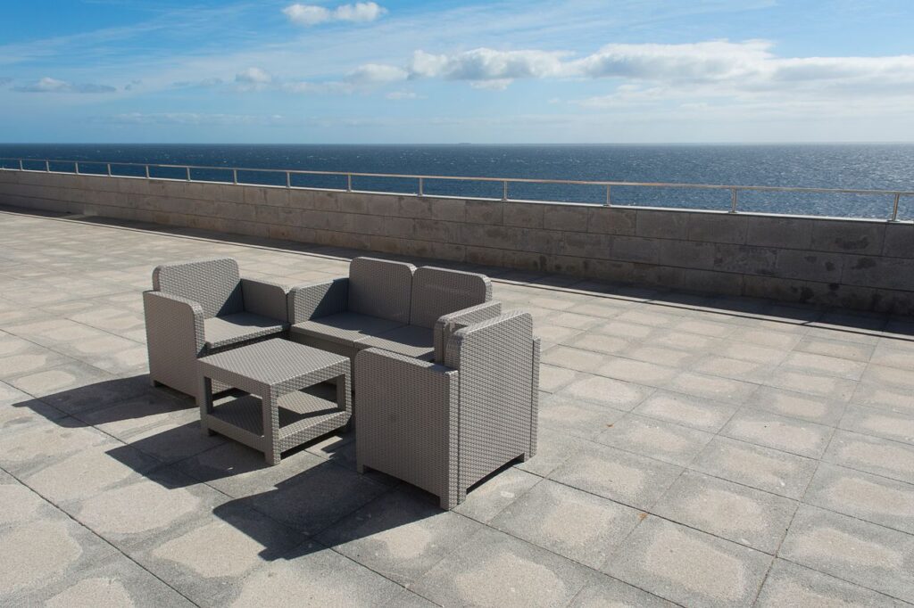 Relaxing outdoor seating area with ocean view on a sunny day.