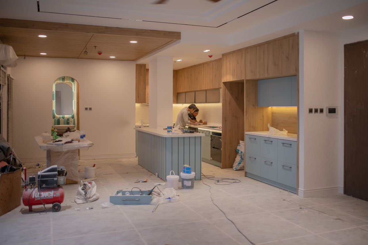Projects A modern kitchen undergoing renovation, featuring a worker, tools, and materials.
