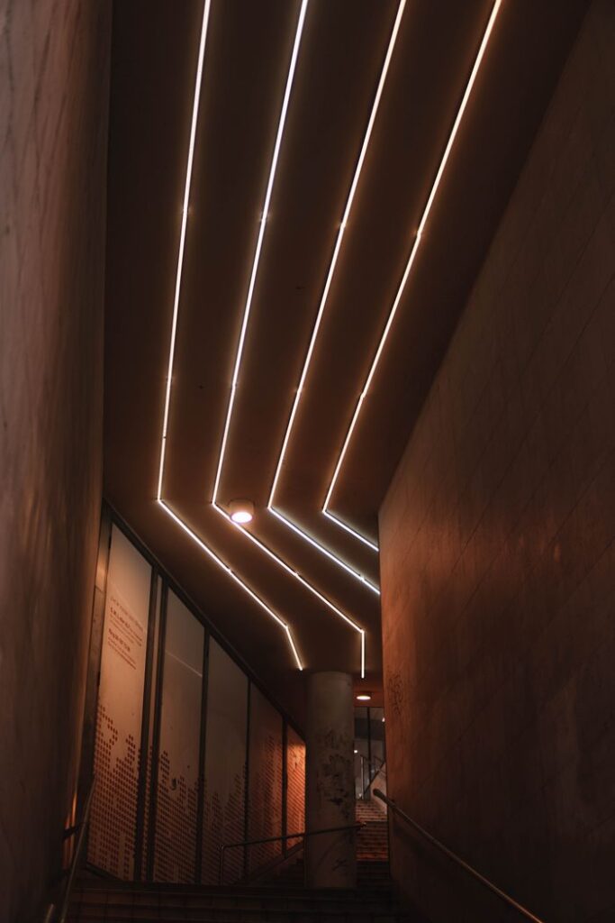 Contemporary interior staircase with striking geometric lighting for modern architecture.